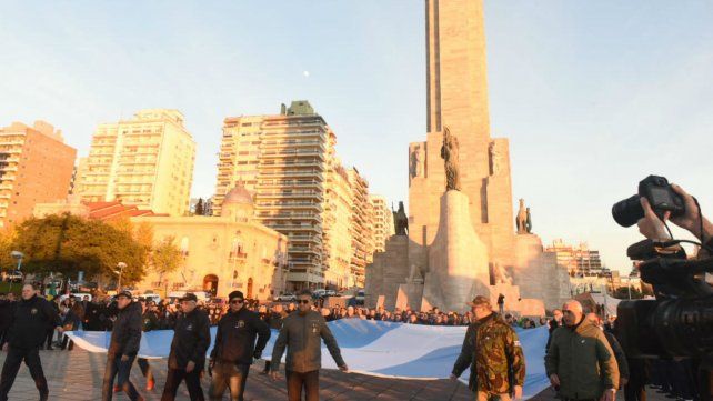 Los Veteranos de Malvinas llevan la bandera hasta el mástil mayor para el izamiento. 