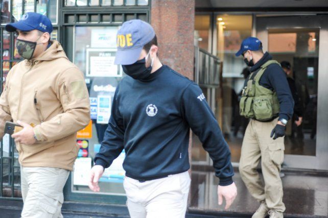 Efectivos de la Tropa de Operaciones Especiales salen del departamento del fiscal.