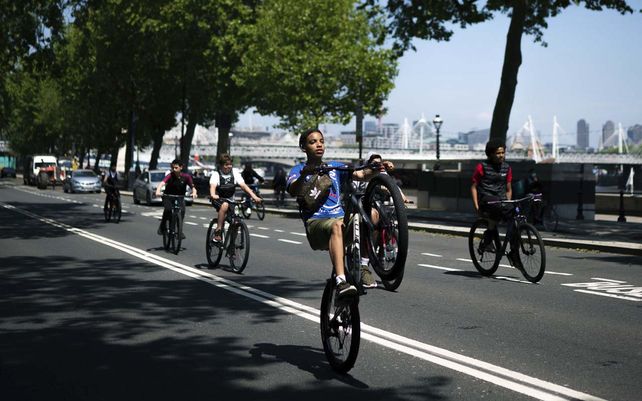 Un grupo de niños andan en bicicleta a lo largo del Embankment