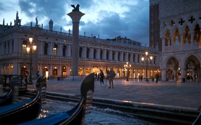 Un hombre toma fotografías junto a las góndolas estacionadas cerca de la plaza de San Marcos. El impacto económico del nuevo brote de coronavirus, afecta a la ciudad por excelencia de Italia.