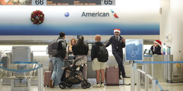 Los empleados de American Airlines, algunos con gorros de Papá Noel, registran a los pasajeros en la terminal de American en el Aeropuerto Internacional de Miami, en Nochebuena, el martes 24 de diciembre de 2024, en Miami. (Foto AP/Rebecca Blackwell)