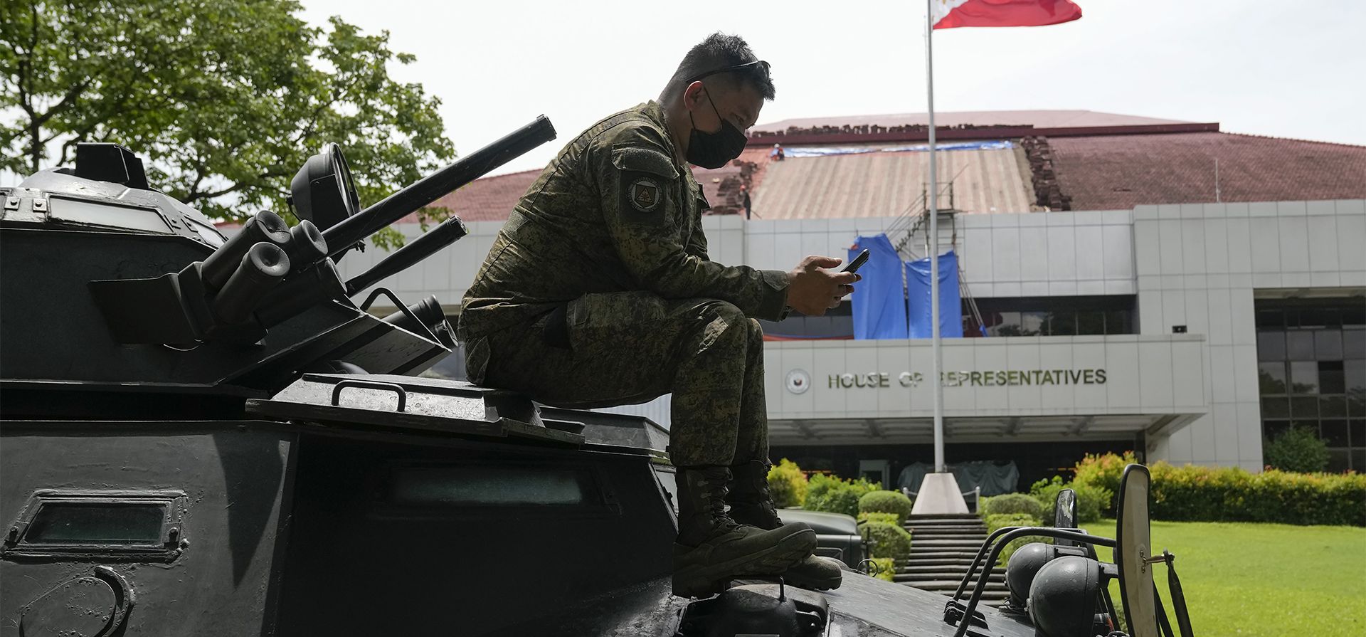 Un soldado espera sobre un vehículo blindado de transporte de personal mientras aseguran el área donde llegan las urnas que contienen los certificados de escrutinio y los resultados electorales a la Cámara de Representantes en Quezon City, Filipinas, el lunes 23 de mayo de 2022.
