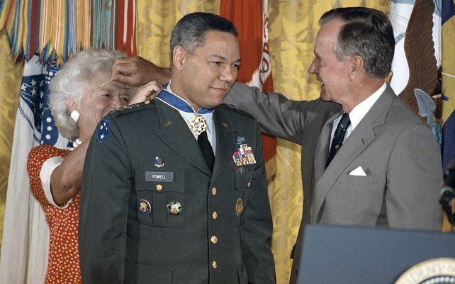 El presidente George Bush presta sus lentes a la primera dama Barbara Bush mientras le coloca una Medalla de la Libertad al general Colin Powell, presidente del Estado Mayor Conjunto, foto archivo. Powell ha fallecido hoy por complicaciones de COVID-19.