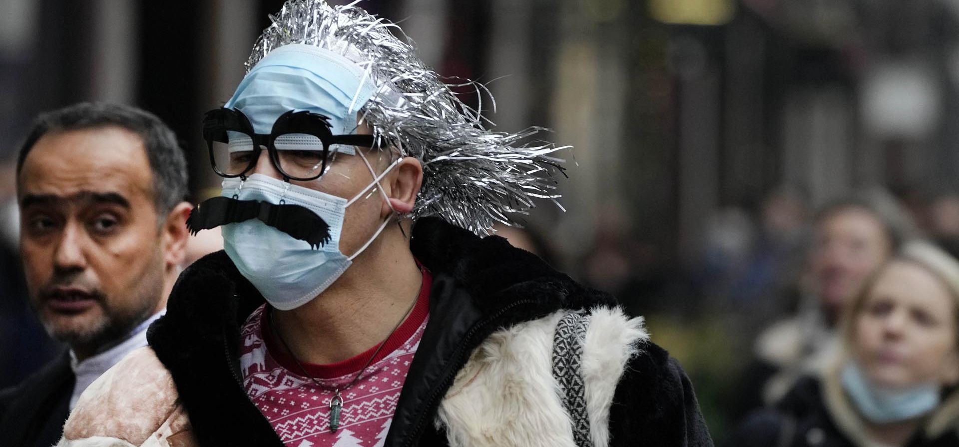 Un hombre con una mascarilla animada, camina por Regents Street en Londres, el jueves 23 de diciembre de 2021. El primer ministro británico, Boris Johnson, dijo el lunes que su gobierno se reserva la 