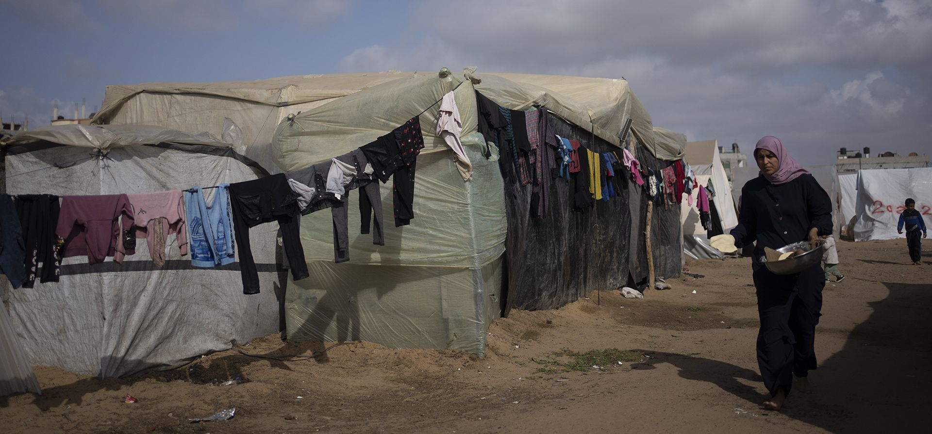 Palestinos desplazados por la ofensiva terrestre israelí en la Franja de Gaza caminan en el campamento improvisado en Rafah el martes 23 de enero de 2024. (Foto AP/Fatima Shbair) Palestinos desplazados por la ofensiva terrestre israelí en la Franja de Gaza caminan en el campamento improvisado en Rafah el martes 23 de enero de 2024. (Foto AP/Fatima Shbair)