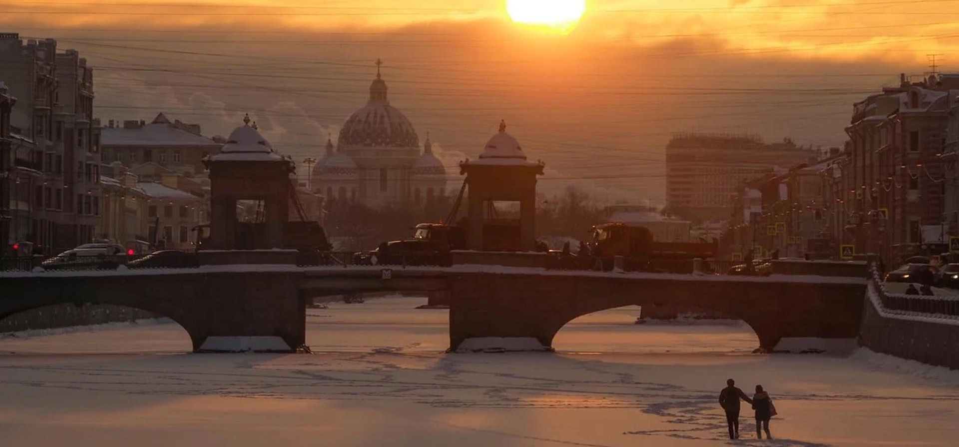 Una pareja camina sobre el hielo del río Fontanka congelado al atardecer en San Petersburgo, Rusia, el jueves 4 de febrero de 2021, con la catedral de Troitsky (Trinidad) de fondo. La temperatura en San Petersburgo bajó a menos 12 grados centígrados. Foto: AP