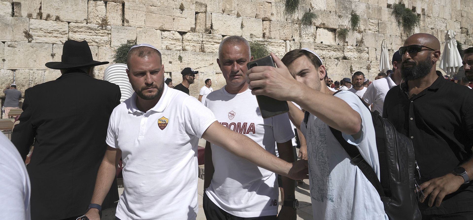 El entrenador del club de fútbol de la Roma, José Mourinho, en el centro, posa para una selfie mientras él y los jugadores del club visitan el Muro Occidental en la Ciudad Vieja de Jerusalén, el viernes 29 de julio de 2022, un día antes de su partido con el Tottenham Hotspur.