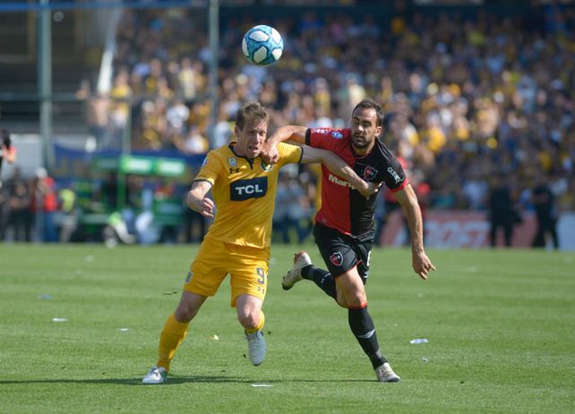 Gentiletti trata de frenar la potente entrada de Claudio Riaño.