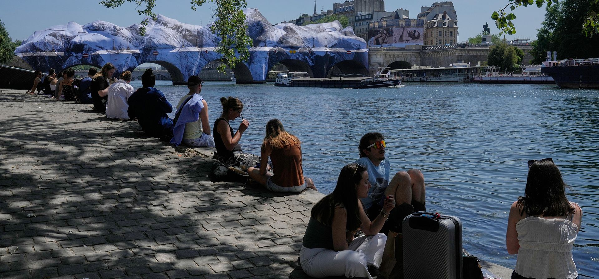 Varias personas buscan alivio del calor a orillas del río Sena en París, el lunes 25 de mayo de 2026. Al fondo se aprecia una obra del artista callejero JR en el Pont Neuf. (Foto AP/Michel Euler) Varias personas buscan alivio del calor a orillas del río Sena en París, el lunes 25 de mayo de 2026. Al fondo se aprecia una obra del artista callejero JR en el Pont Neuf. (Foto AP/Michel Euler)