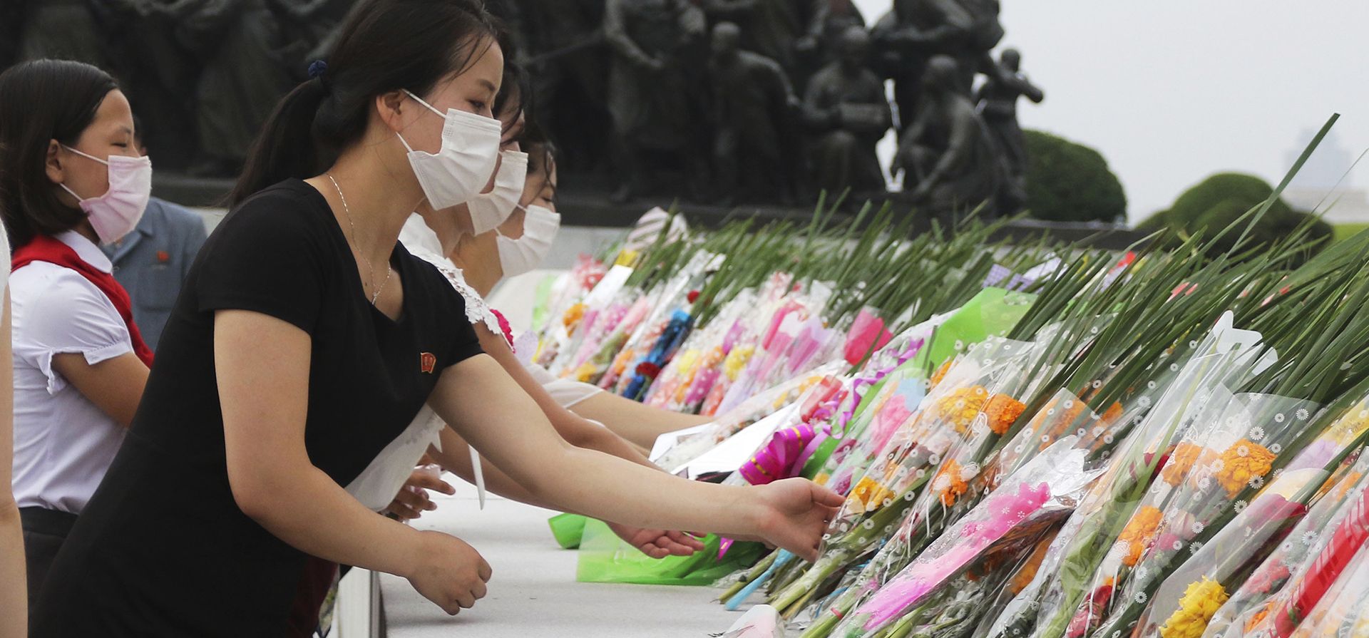 La gente deposita ramos de flores en las estatuas de los exlíderes norcoreanos Kim Il Sung y Kim Jong Il en la colina Mansu en Pyongyang, Corea del Norte, el miércoles 27 de julio de 2022, con motivo del 69 aniversario del fin de la Guerra de Corea.