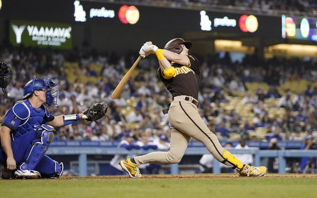 Jake Cronenworth, de los Padres de San Diego, conecta un jonrón solitario mientras el receptor de los Dodgers de Los Ángeles Will Smith observa durante la novena entrada de un juego de béisbol en Los Ángeles.