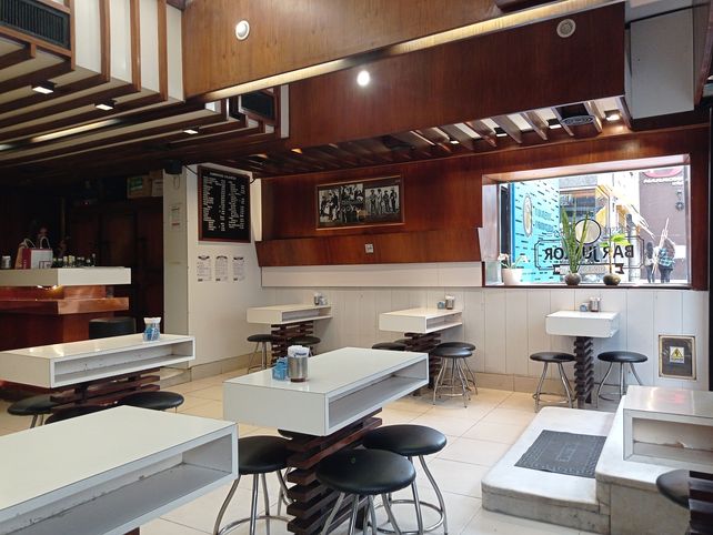 Bar junior por dentro, exhibiendo sus clásicas mesas y banquitos.