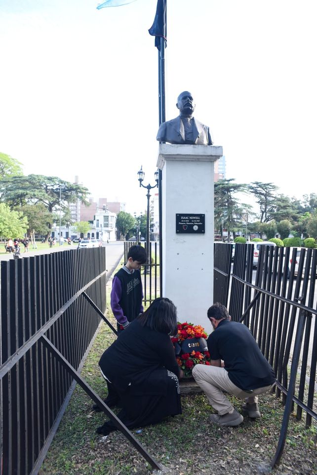 Los bisnietos y el tataranieto de Isaac Newell colocan una ofrenda floral.