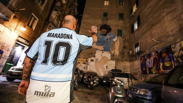 Un hincha del Napoli se acerca a la imagen de Diego Maradona ubicada en el centro de la ciudad.