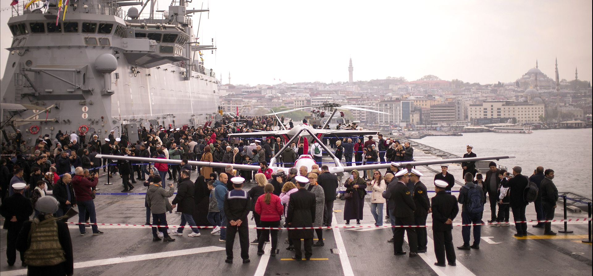 El público asiste al puerto de Estambul, Turquía, para ver los vehículos aéreos de combate no tripulados (UCAV) Bayraktar TB3, parte delantera, y Bayraktar Kizilelma a bordo del buque de asalto anfibio turco TCG Anadolu L400, el jueves 20 de abril de 2023. (Foto AP/Francisco Seco )