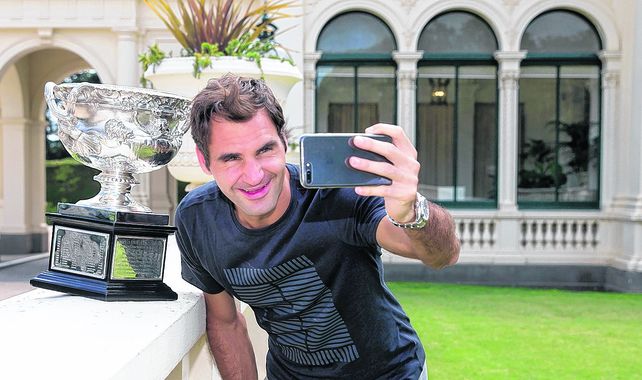 Alta selfie. Federer posa con el trofeo Norman Brookes con la casa de gobierno de Melbourne de fondo.El suizo ganó por sexta vez el abierto de tenis de Australia a los 36 años.