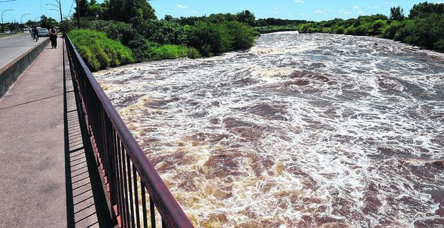 amenaza. El agua baja con fuerza y la erosión de la cascada pone en riesgo la estabilidad del puente.