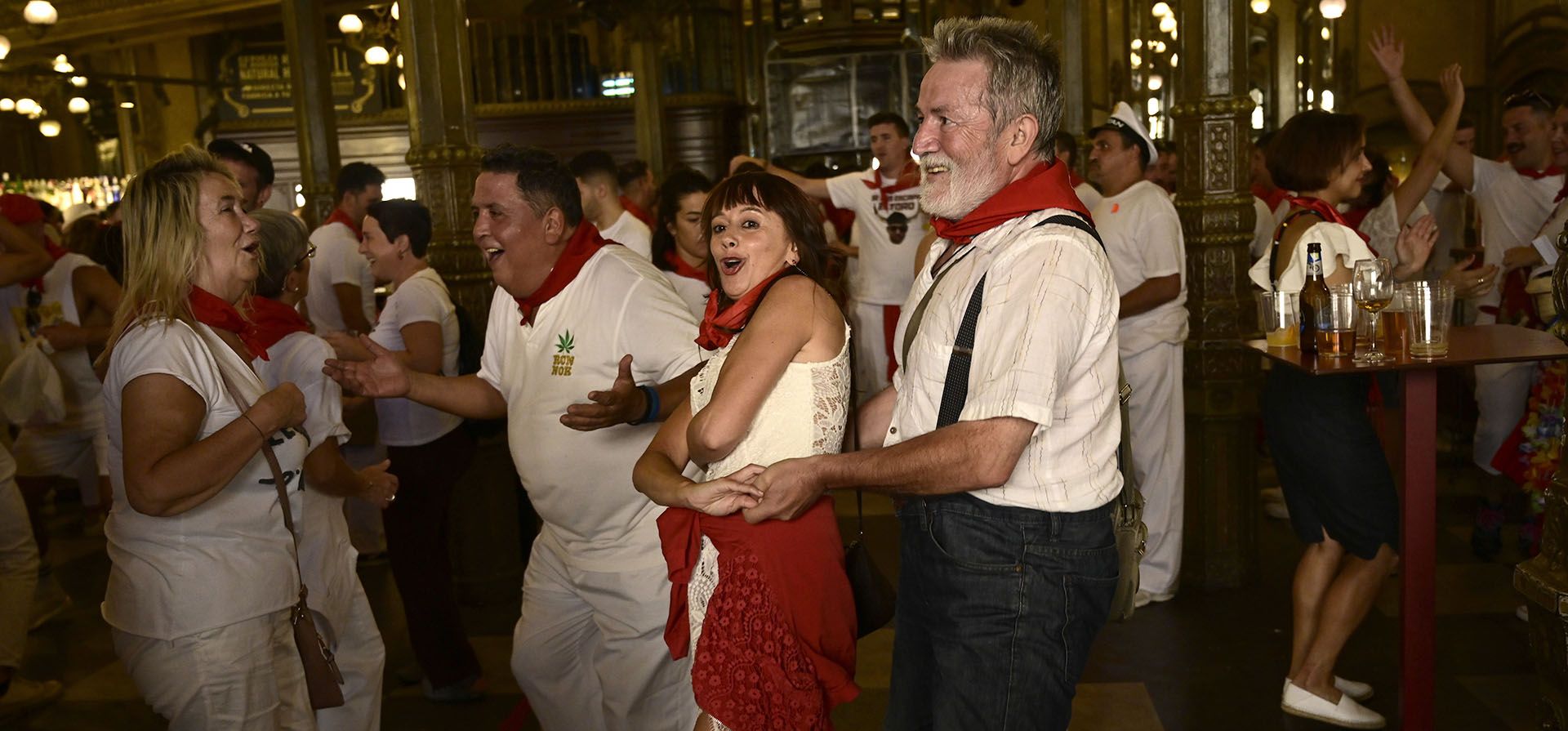 Gente baila en las Fiestas de San Fermín en Pamplona, norte de España, el viernes 8 de julio de 2022. Turistas de todo el mundo acuden a la ciudad cada año durante nueve días de fiesta ininterrumpida en el famoso festival de corridas de toros de Pamplona, que estuvo suspendido durante los últimos dos años debido a la pandemia de coronavirus.
