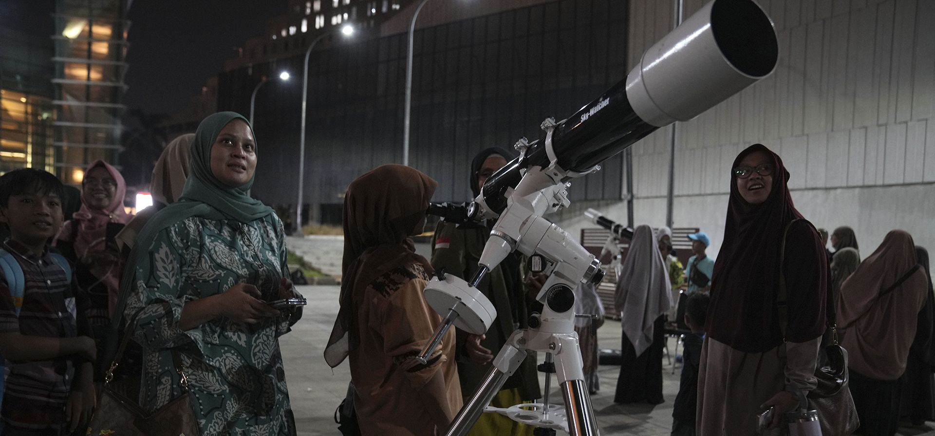 La gente espera su turno para usar un telescopio proporcionado por el Planetario de Yakarta para ver la salida de la luna, en Yakarta, Indonesia, el jueves 17 de octubre de 2024. (Foto AP/Dita Alangkara) La gente espera su turno para usar un telescopio proporcionado por el Planetario de Yakarta para ver la salida de la luna, en Yakarta, Indonesia, el jueves 17 de octubre de 2024. (Foto AP/Dita Alangkara)