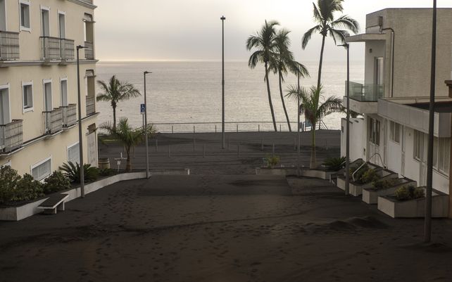 La ceniza cubre una de las calles del pueblo de Puerto Naos mientras el volcán continúa en erupción en la isla canaria de La Palma