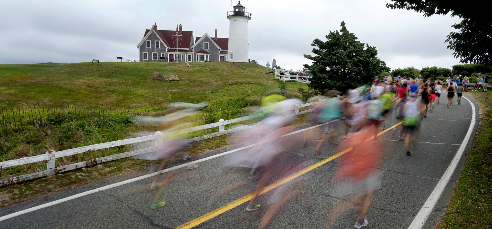 Participantes de una maratón pasan por el faro de Nobska cerca de la marca de 1 milla de la carrera Falmouth Road Race, el domingo 18 de agosto de 2024, en Falmouth, Massachusetts. (Foto AP/Jeff Roberson) Participantes de una maratón pasan por el faro de Nobska cerca de la marca de 1 milla de la carrera Falmouth Road Race, el domingo 18 de agosto de 2024, en Falmouth, Massachusetts. (Foto AP/Jeff Roberson)