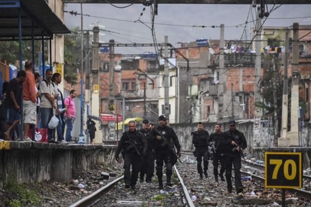 paisaje. Policías caminan por las vías del ferrocaril antes de irrumpir en la favela Jacarezinho.