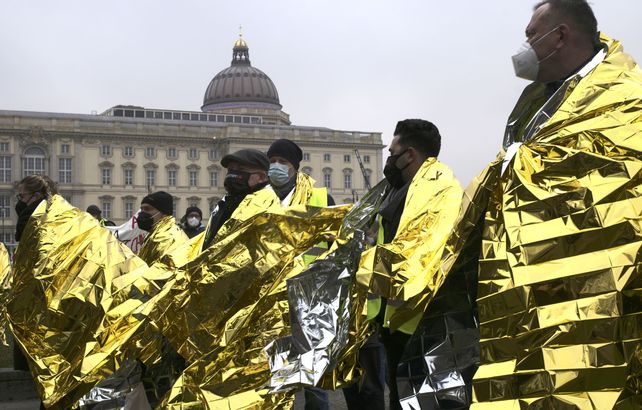 Empleados públicos de la ciudad de Berlín se cubren con mantas de rescate doradas asisten a una huelga de advertencia para un lograr un mejor salario