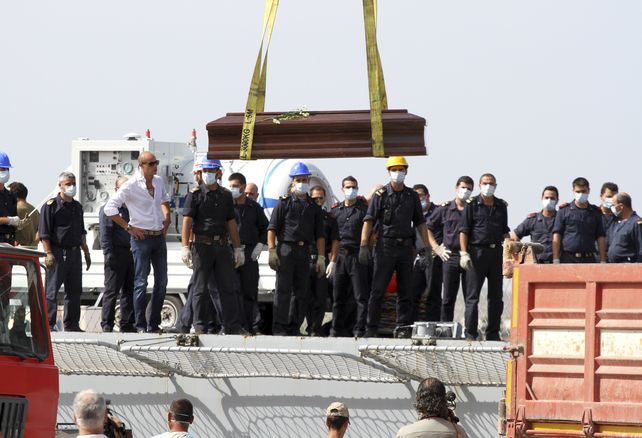 El ataúd de una de las 363 víctimas del primer naufragio es subido a una nave italiana en Lampedusa.
