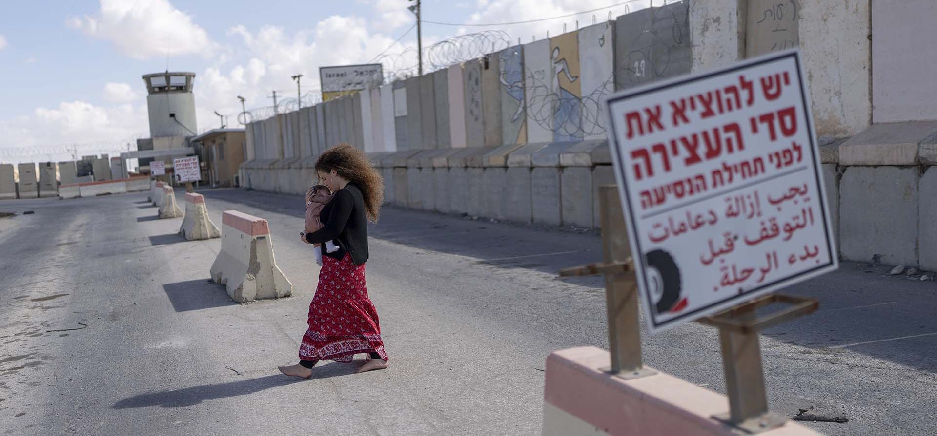 Una mujer sostiene a un bebé mientras se encuentra en un área en el cruce fronterizo de Nitzana con Egipto, en el sur de Israel, el miércoles 14 de febrero de 2024. (Foto AP/Ohad Zwigenberg) Una mujer sostiene a un bebé mientras se encuentra en un área en el cruce fronterizo de Nitzana con Egipto, en el sur de Israel, el miércoles 14 de febrero de 2024. (Foto AP/Ohad Zwigenberg)