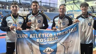 Los Rossetto, Tomás y papá Daniel en el medio, Tomás Iraci y Gino Cacciabue a los costados, con la bandera del club Libertad que brilló en el torneo de karate en Italia.