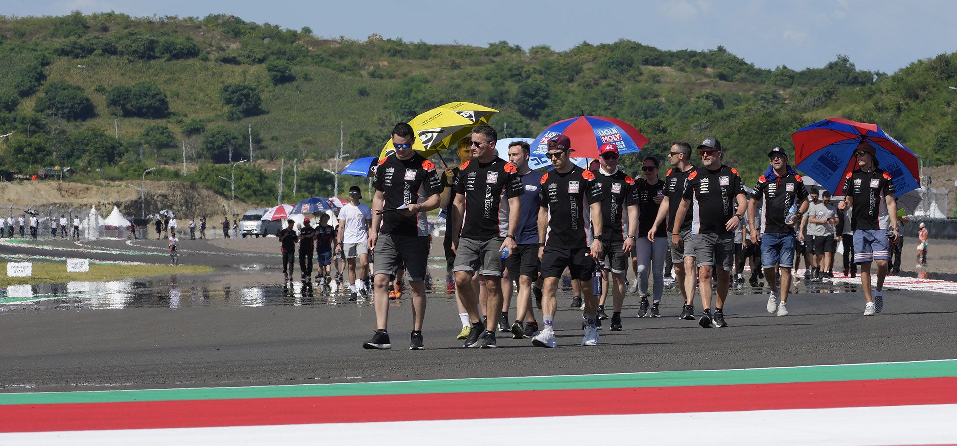 Los pilotos y los miembros de su tripulación caminan durante la familiarización con la pista antes de la competencia de MotoGP del domingo en el Grand Prix del circuito Pertamina Mandalika en Mandalika, isla de Lombok, Indonesia.