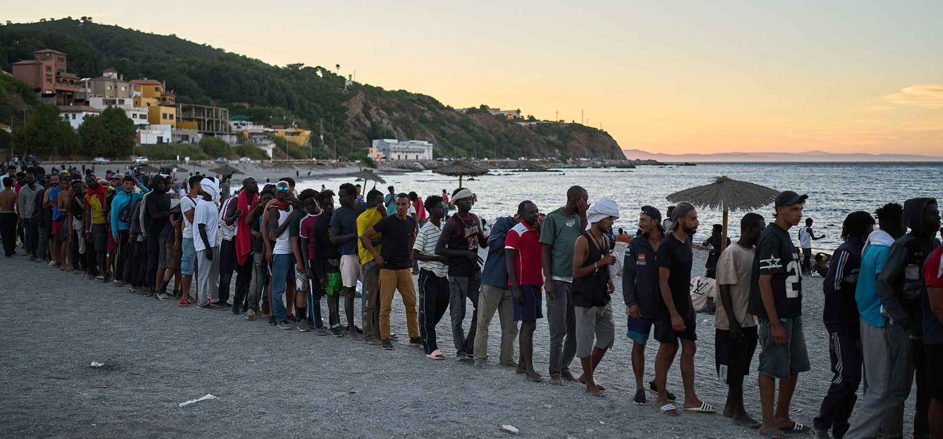 Migrantes que cruzaron desde Marruecos a España hacen fila para recibir comida en una playa en el territorio español de Ceuta, el lunes 3 de agosto de 2026. (AP Foto/Bernat Armangue) Migrantes que cruzaron desde Marruecos a España hacen fila para recibir comida en una playa en el territorio español de Ceuta, el lunes 3 de agosto de 2026. (AP Foto/Bernat Armangue)