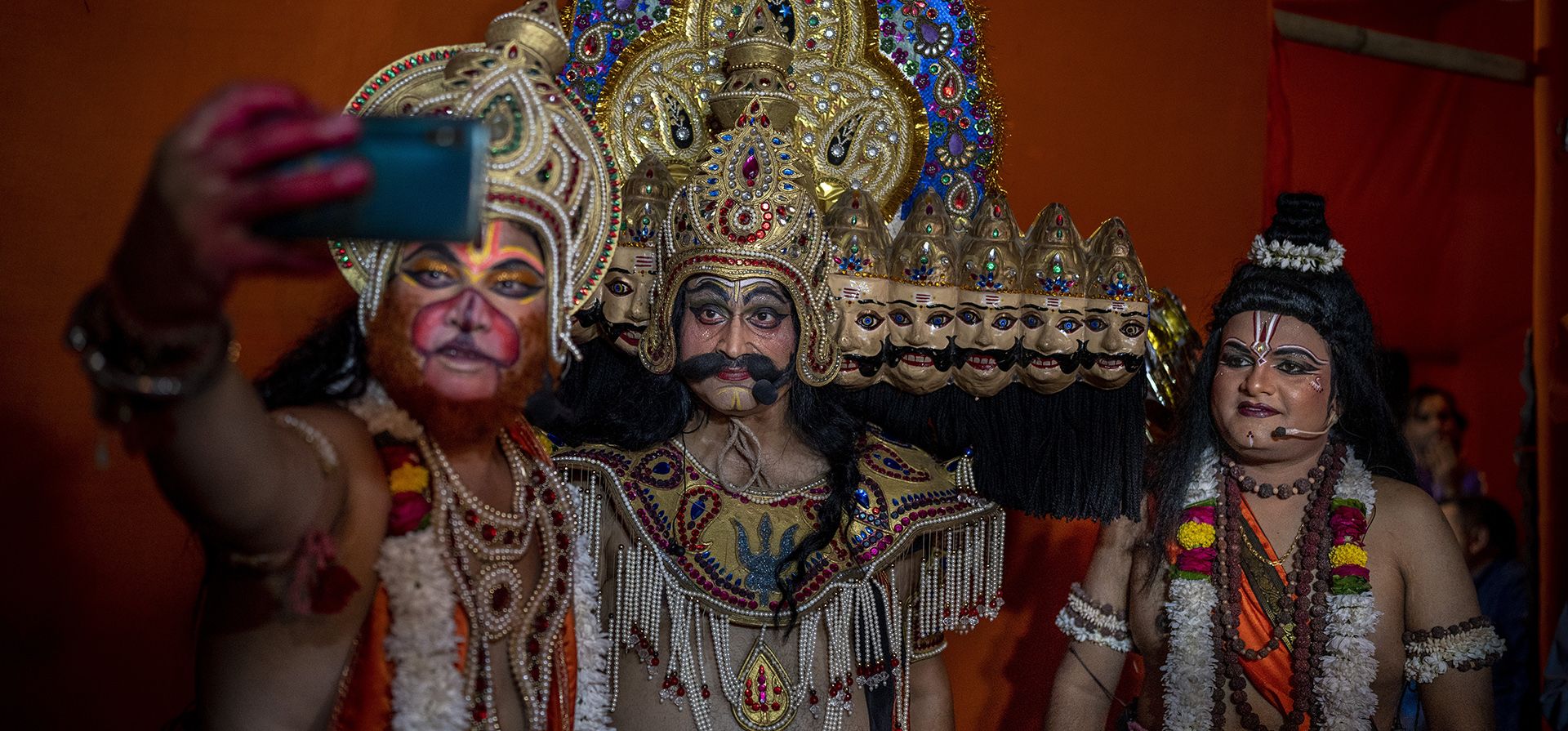 Un artista vestido como el dios mono hindú Hanuman, se toma una selfie con artistas vestidos como el rey demonio Ravana, en el centro, y el dios hindú Ram, antes de una presentación final de Ramleela como parte de las celebraciones del festival Dussehra en Nueva Delhi, India.
