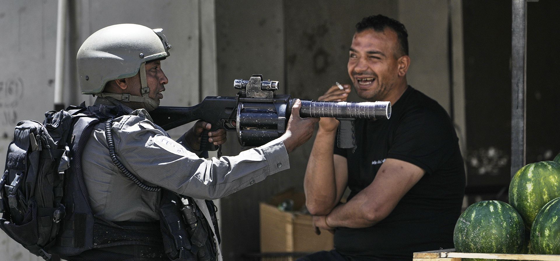 Un agente de la policía fronteriza israelí se posiciona junto a un vendedor de sandías durante una redada militar en el campo de refugiados de Askar, cerca de la ciudad cisjordana de Nablus, el martes 20 de mayo de 2025. (Foto AP/Majdi Muhammad) Un agente de la policía fronteriza israelí se posiciona junto a un vendedor de sandías durante una redada militar en el campo de refugiados de Askar, cerca de la ciudad cisjordana de Nablus, el martes 20 de mayo de 2025. (Foto AP/Majdi Muhammad)