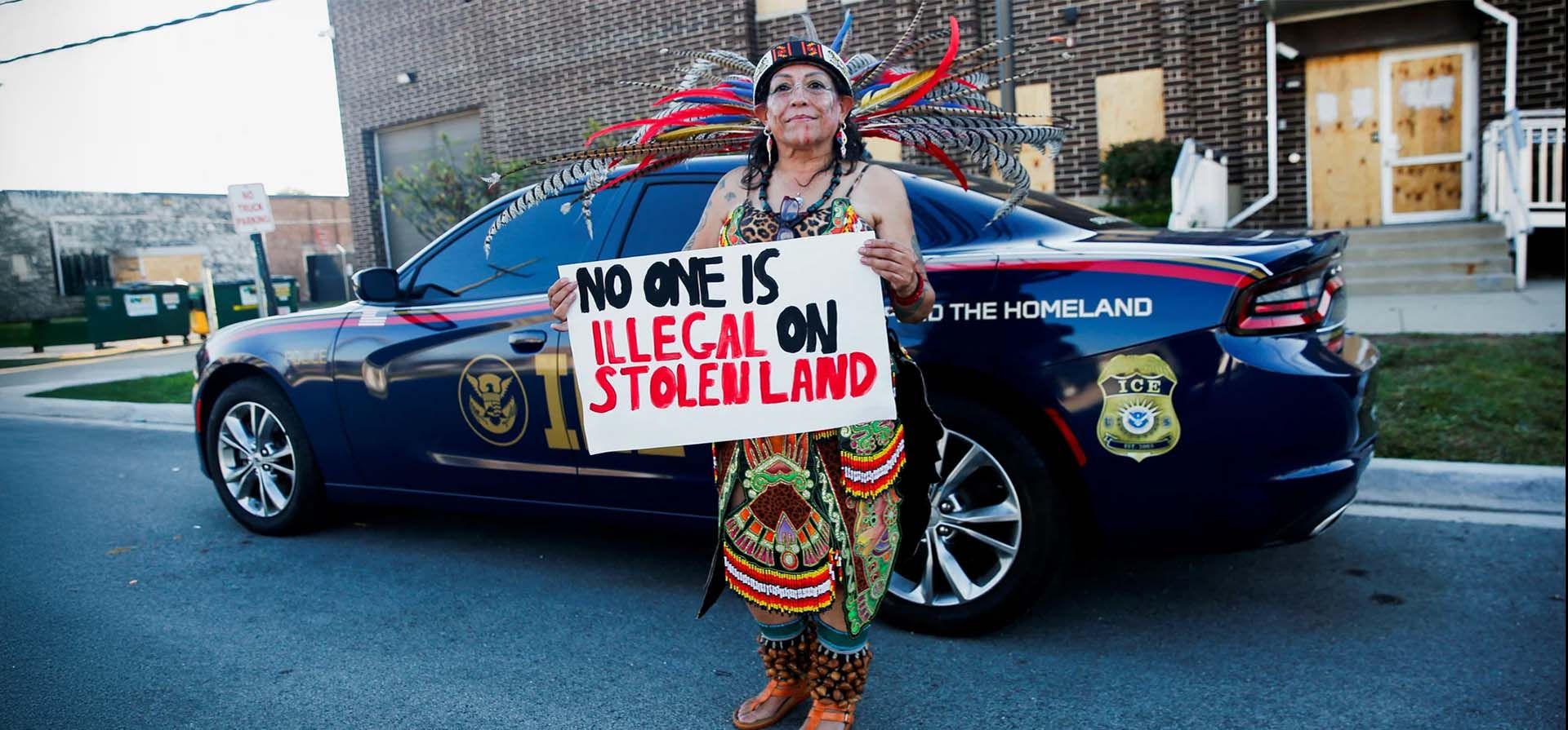 Con una prenda tradicional mexicana, Rosa Gayton posa para un retrato mientras sostiene un cartel que dice: Con una prenda tradicional mexicana, Rosa Gayton posa para un retrato mientras sostiene un cartel que dice: