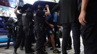 Los jugadores descendieron del colectivo cubiertos por los escudos policiales.