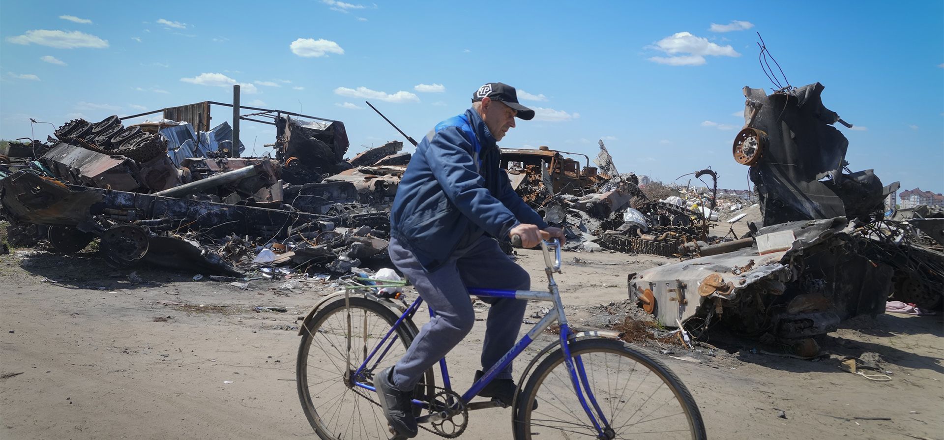 Un residente local pasa en bicicleta frente a un vehículo militar ruso destruido en Bucha, en las afueras de Kiev, Ucrania, el martes 10 de mayo de 2022.