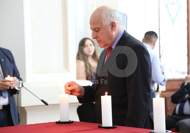 El gobernador encendiendo una de las seis velas que representan cada millón de judíos víctimas del genocidio.