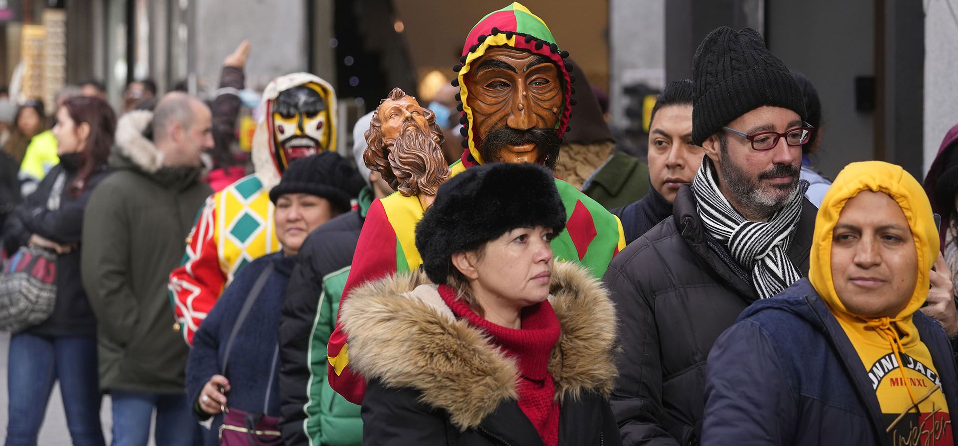Dos personas con máscaras se unen a una fila de boletos de lotería de Navidad en el centro de Madrid, España, el miércoles 21 de diciembre de 2022. El extraordinario sorteo de lotería de Navidad de España conocido como El Gordo se llevará a cabo el 22 de diciembre. (Foto AP/ Pablo Blanco)