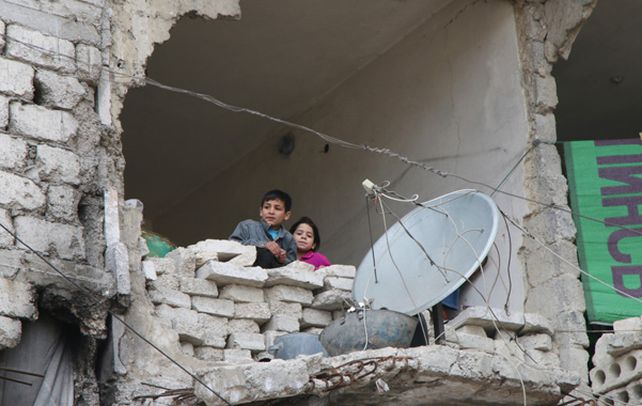 El Drama de la guerra. Niños observan desde una de los miles de viviendas destruidas por las bombas en Alepo.