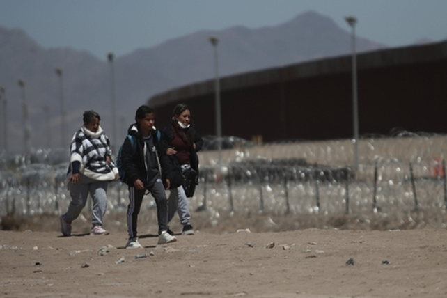 Migrantes mexicanos se acercan al muro que cierra la frontera con EEUU en la zona de Ciudad Juárez.