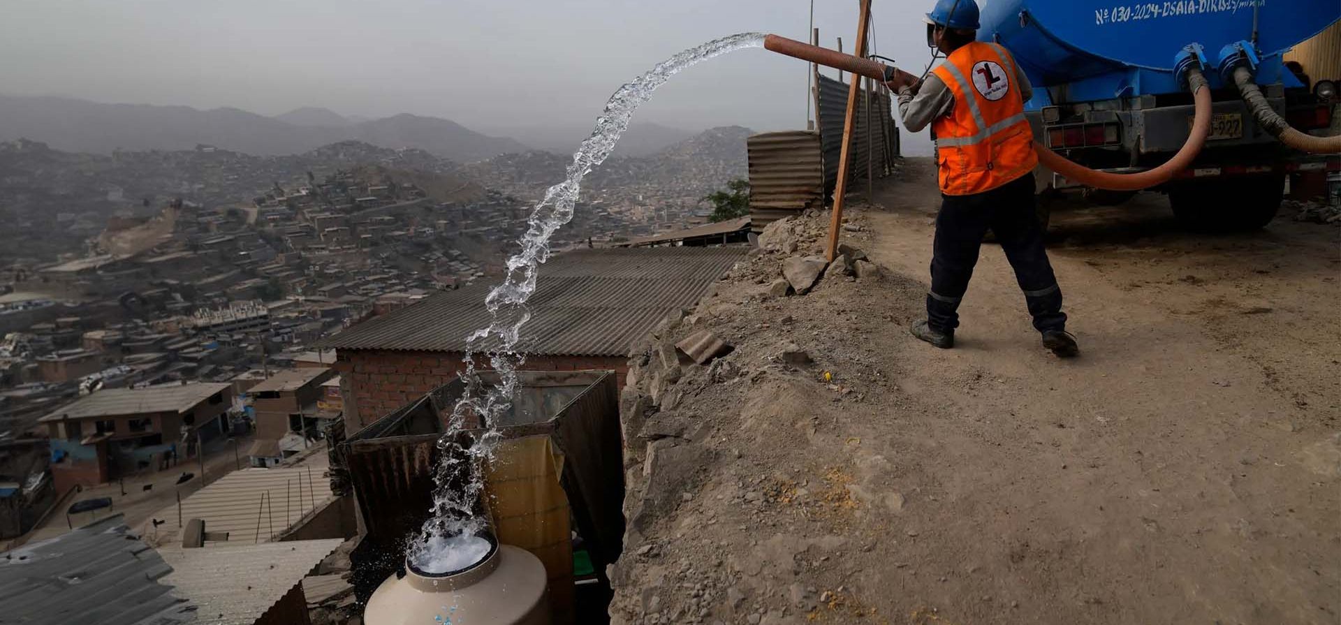 Un trabajador de un camión cisterna llena un contenedor en el exterior de las casas de los vecinos que lo utilizan para beber, cocinar y limpiar, en la zona de Pamplona Alta, Lima, Perú. Fotografía: Martín Mejía/AP Un trabajador de un camión cisterna llena un contenedor en el exterior de las casas de los vecinos que lo utilizan para beber, cocinar y limpiar, en la zona de Pamplona Alta, Lima, Perú. Fotografía: Martín Mejía/AP