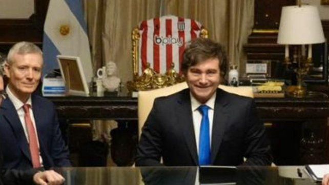 Javier Milei con la camiseta de Estudiantes de fondo.