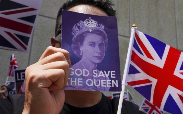 Un manifestante tapa su rostro mientras participa en una manifestación frente al consulado británico en Hong Kong. El gobierno británico dijo este jueves que está estableciendo un fondo de 43 millones de libras para ayudar a los migrantes de Hong Kong a establecerse en el país.