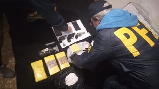 Efectivos de la PFA y parte del secuestro, entre ellos panes de cocaína embalados en cinta amarilla con el bajo relieve de un delfín.