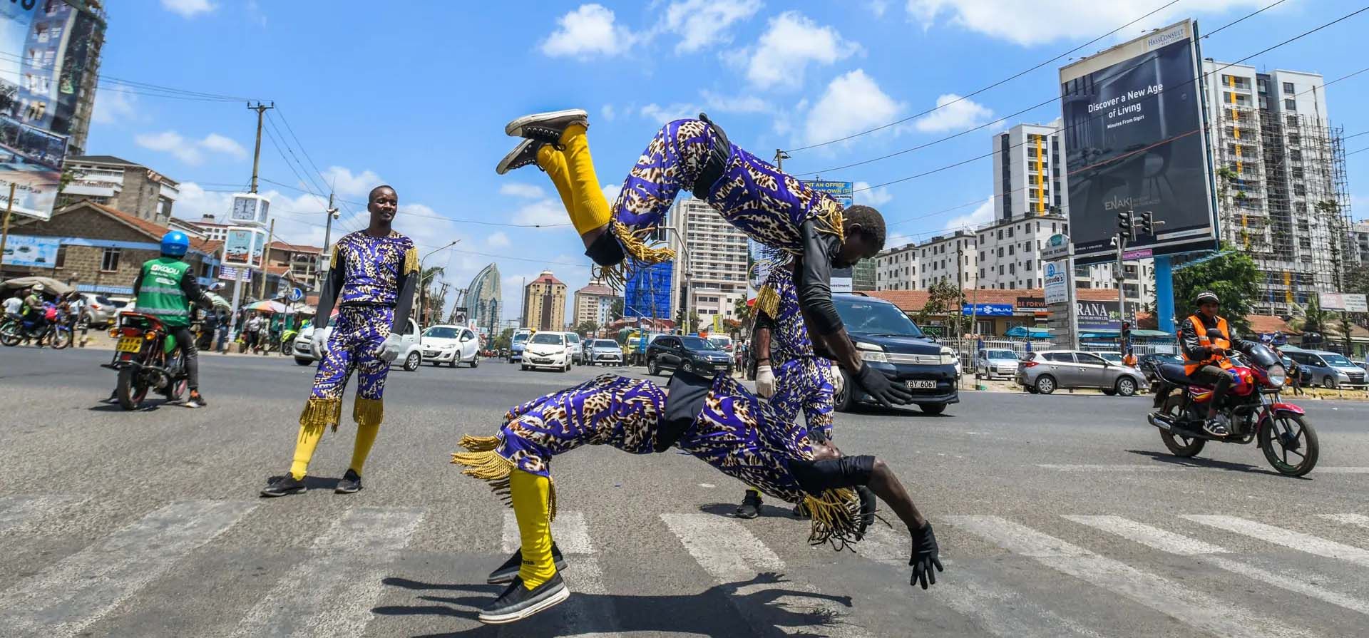 Acróbatas ofrecen una actuación para los conductores que esperan en los semáforos en rojo de la capital de Kenia, Nairobi, Kenia. Fotografía: Gerald Anderson/Anadolu/Getty Images Acróbatas ofrecen una actuación para los conductores que esperan en los semáforos en rojo de la capital de Kenia, Nairobi, Kenia. Fotografía: Gerald Anderson/Anadolu/Getty Images