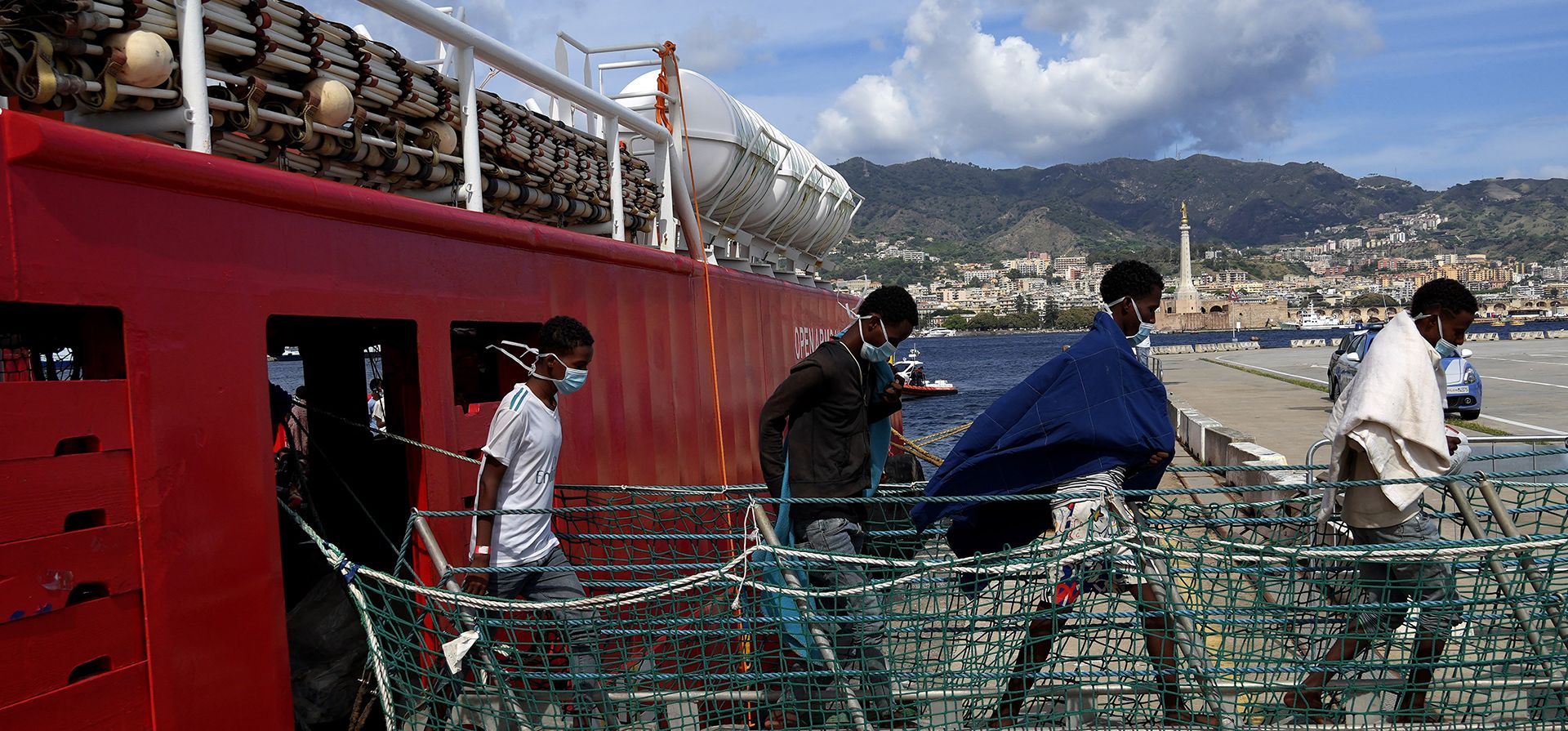 Hombres desembarcan el barco salvavidas de la ONG española Open Arms después de atracar en el puerto de Messina, en Sicilia, Italia, el jueves 22 de septiembre de 2022. Más de cuatrocientos inmigrantes de Egipto, Siria, Pakistán, Bangladesh, Eritrea, Sudán, Etiopía y Somalia fueron rescatado por tripulantes de la ONG Open Arms.