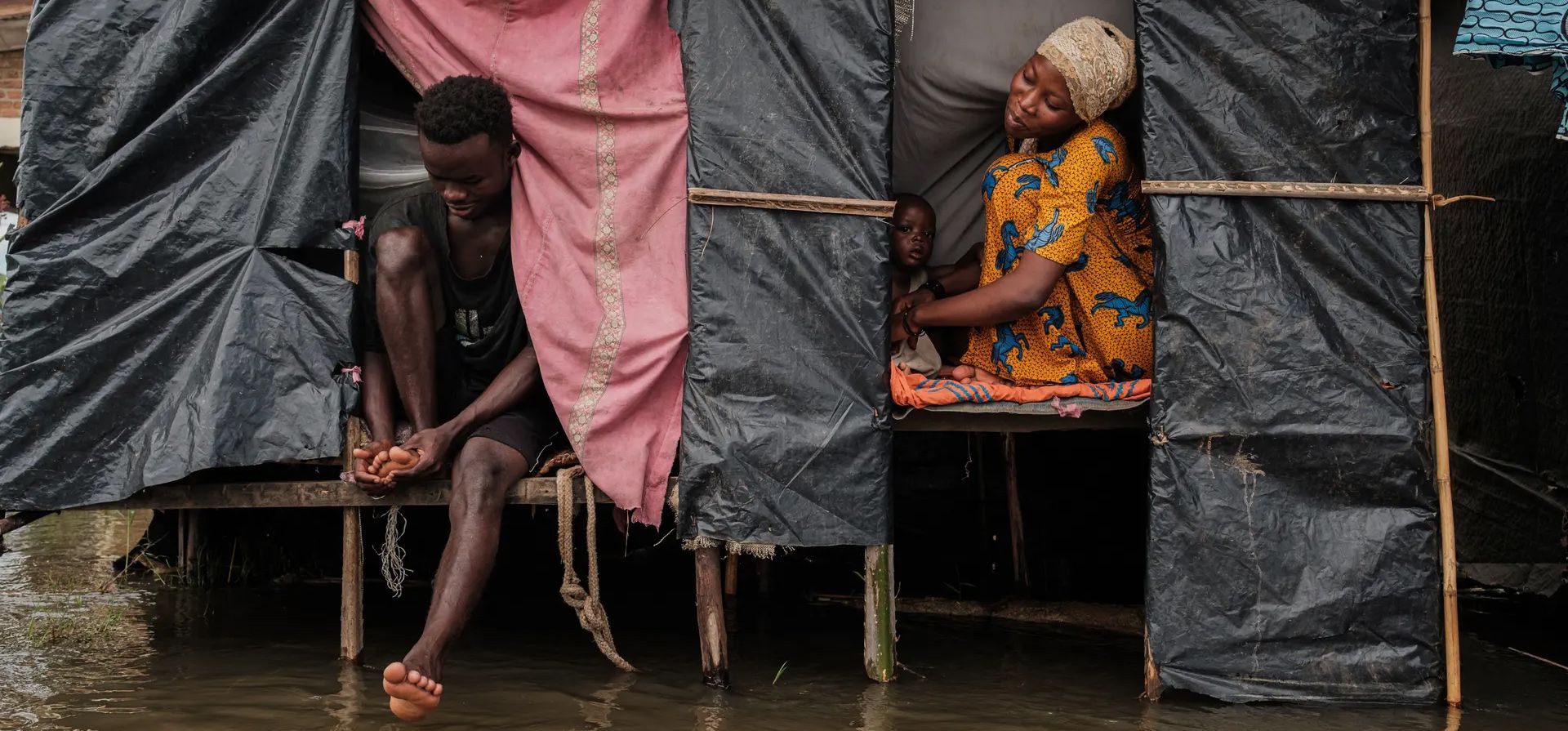 Uwurukundo Zilfa se sienta junto a su esposo y su hijo en su refugio temporal después de haber sido desplazada tras las inundaciones repentinas en el distrito de Gatumba de Bujumbura, Burundi. Fotografía: Tchandrou Nitanga/AFP/Getty Images Uwurukundo Zilfa se sienta junto a su esposo y su hijo en su refugio temporal después de haber sido desplazada tras las inundaciones repentinas en el distrito de Gatumba de Bujumbura, Burundi. Fotografía: Tchandrou Nitanga/AFP/Getty Images