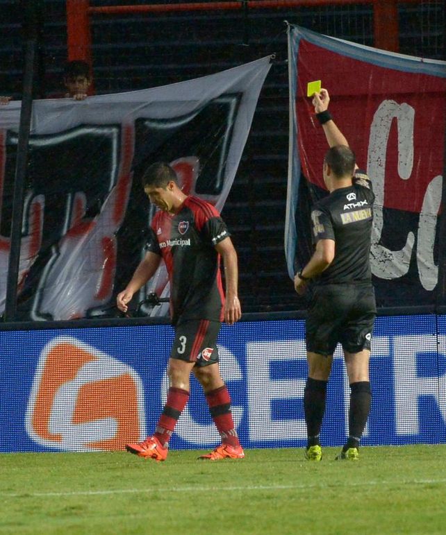 Castigo. Echenique le muestra la tarjeta amarilla al zaguero central tras bajar a un rival. Moiraghi deberá cumplir una fecha.
