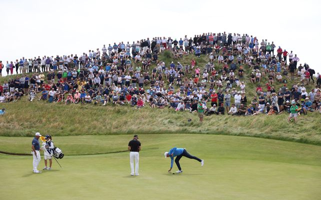 Stewart Cink de Estados Unidos recupera su pelota del hoyo en el sexto green durante la primera ronda del British Open Golf Championship en el campo de golf Royal St Georges Sandwich